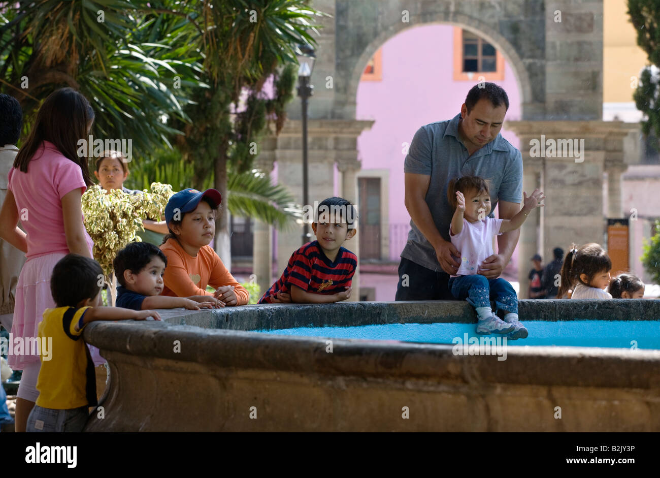 MEXIKANISCHE Kinder und Erwachsene spielen in der Nähe eines Brunnens in der historischen Stadt GUANAJUATO Mexiko Stockfoto
