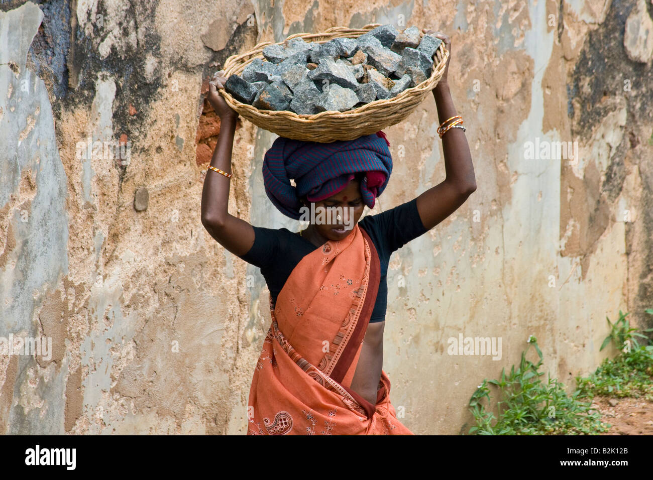 Frau trägt Schwerlast während Buiding eine Straße in Chettinad Süd-Indien Stockfoto