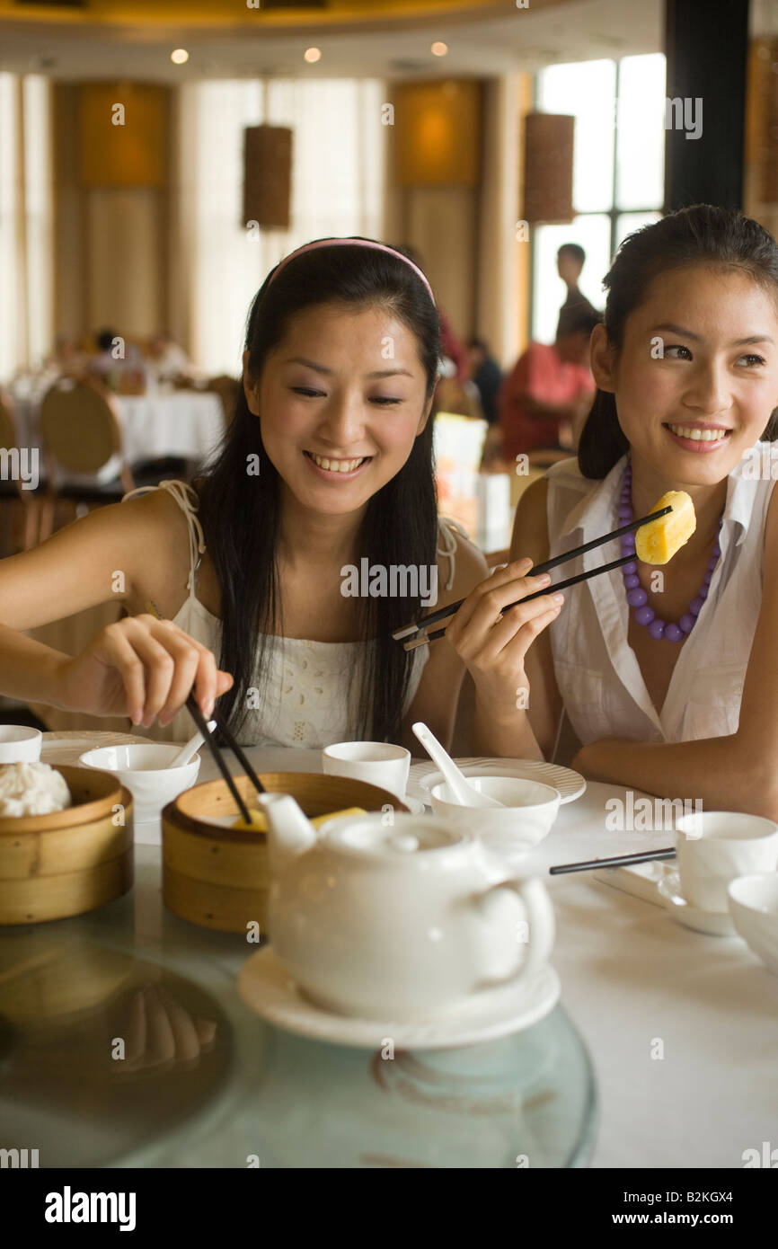 Zwei junge Frauen, die Dim Sum in einem Restaurant Essen Stockfoto