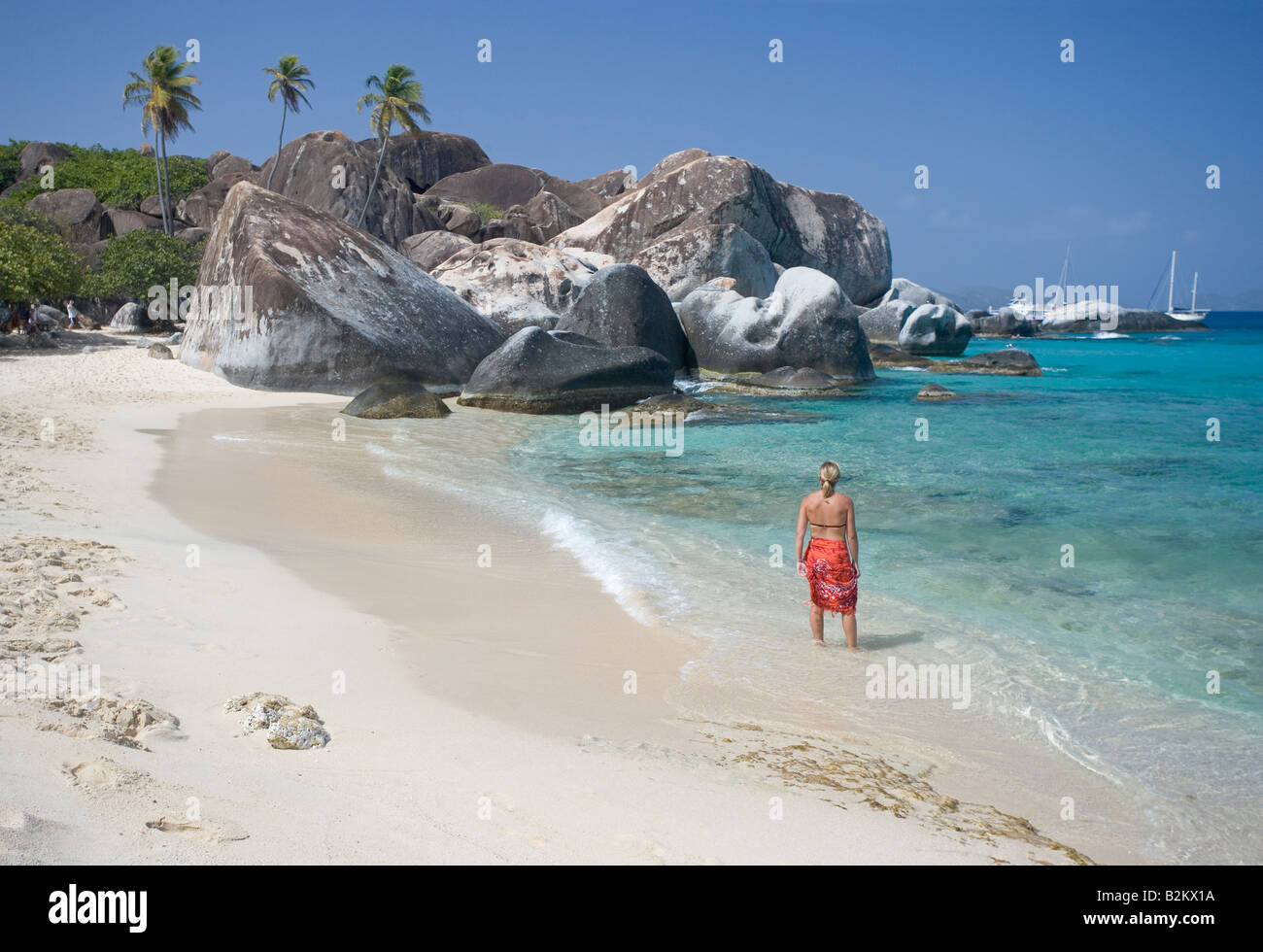Eine Frau in den Urlaub geht an einem Strand in der Nähe der Bäder auf Virgin Gorda BVI Stockfoto