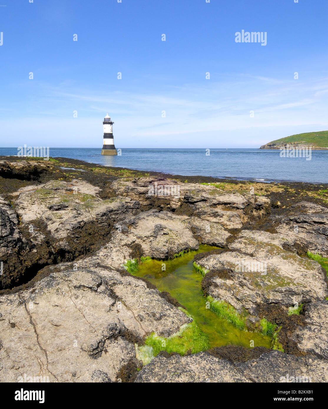 Penmon Point Lighthouse und Puffin Island vor der felsigen und tückischen Küste von Anglesey in Nord-Wales Stockfoto