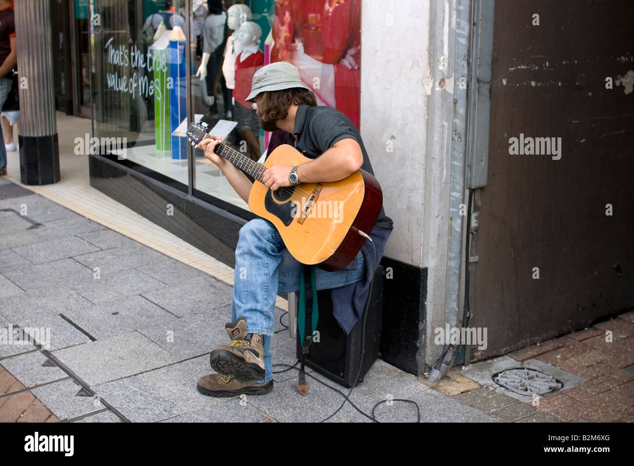 Ein Straßenmusikant spielt Gitarre in Kingston-upon-Thames, London Stockfoto