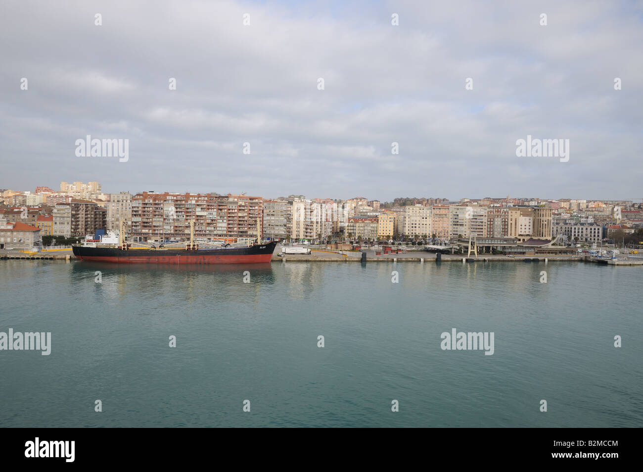 Coastal Frachter Oluk an der Kai-Seite auf der Ria de Bilbao oder Fluss Nervion Spanien A LKW festgemacht ist neben mehrstöckigen ap Stockfoto