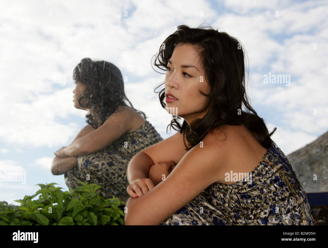 Chinesisches Mädchen und ihre Reflexion in einem Spiegel Stockfoto