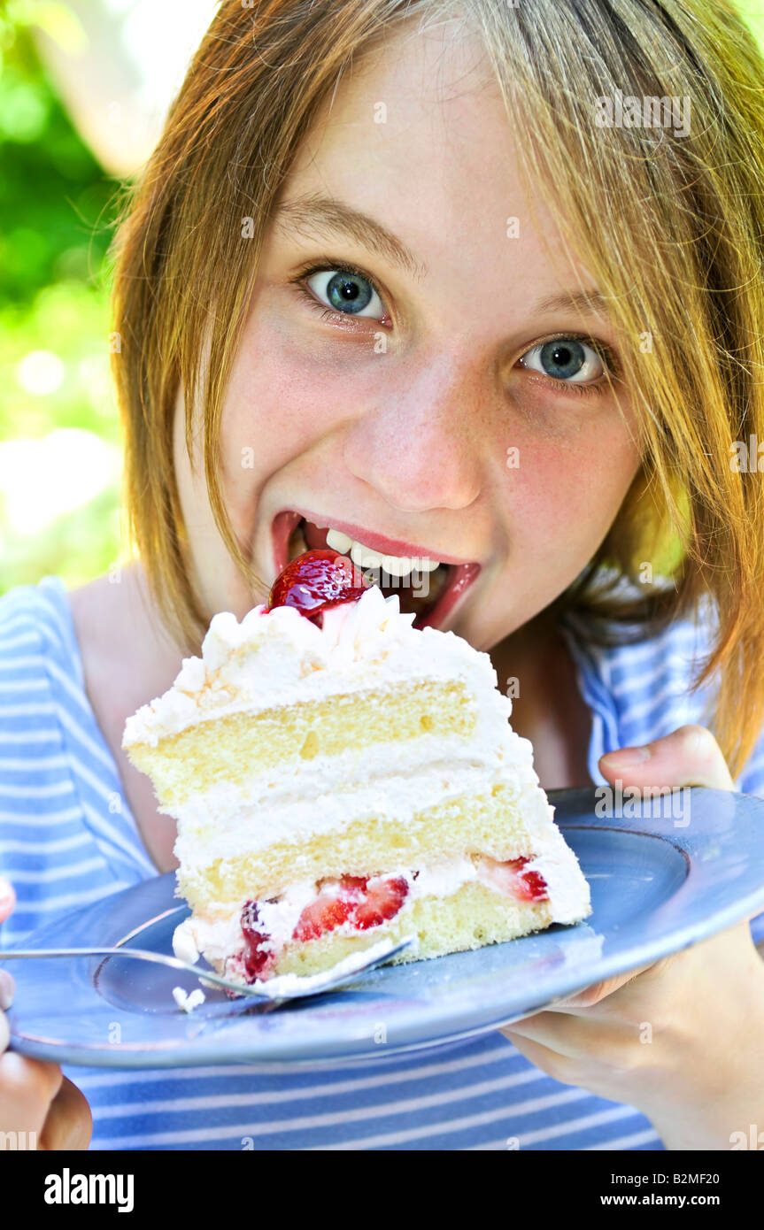 Teenager-Mädchen essen ein Stück Erdbeerkuchen Stockfoto
