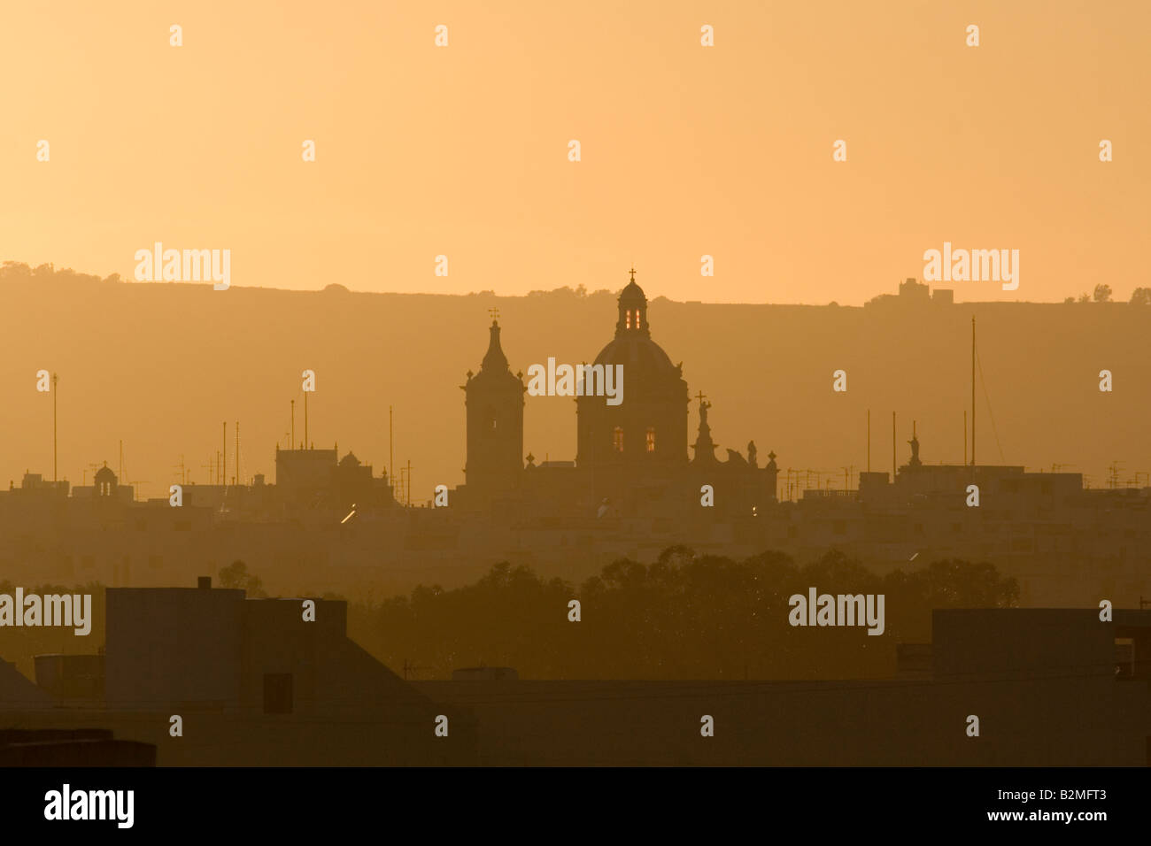 Maltesische Landschaft. Mqabba, Malta, bei Sonnenuntergang, mit der katholischen Pfarrkirche dominiert die Skyline. Keine Filter oder Farbmanipulation verwendet. Stockfoto