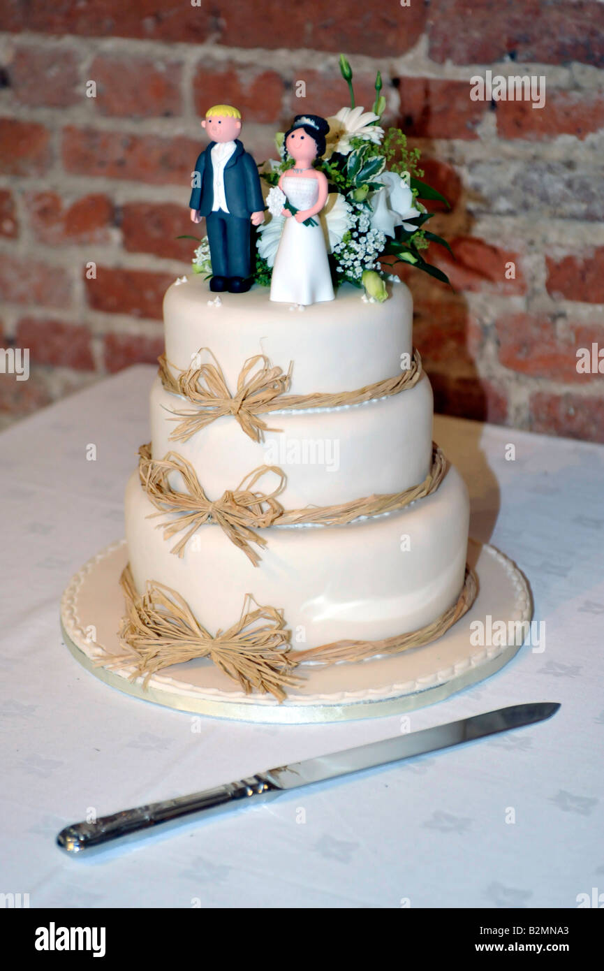 Hochzeitstorte mit humorvollen Figuren der Braut und des Bräutigams Stockfoto