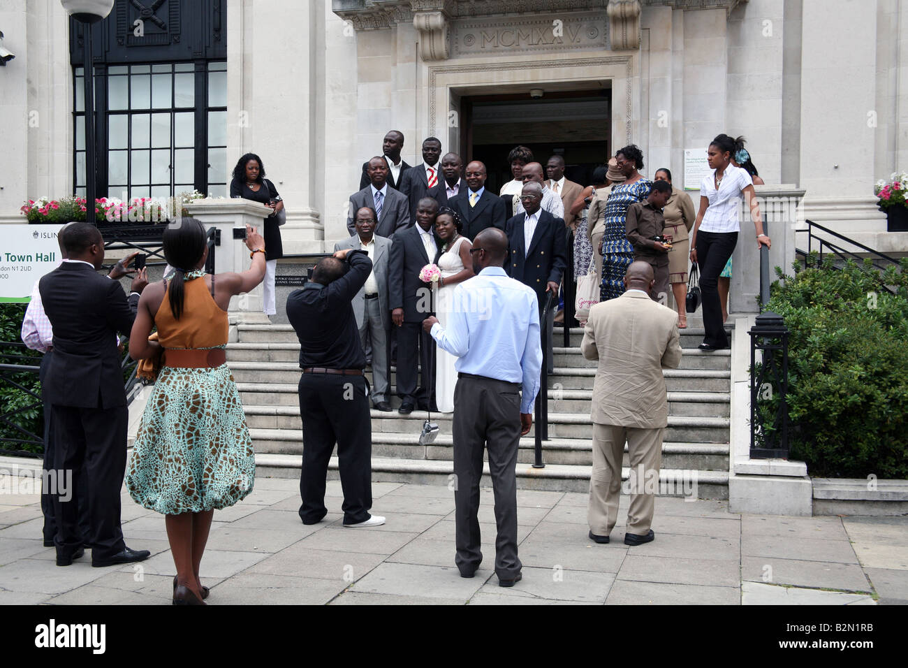 Mitglieder der schwarzen britischen Gemeinschaft darstellen für Hochzeitsfotos vor Rathaus in London Stockfoto