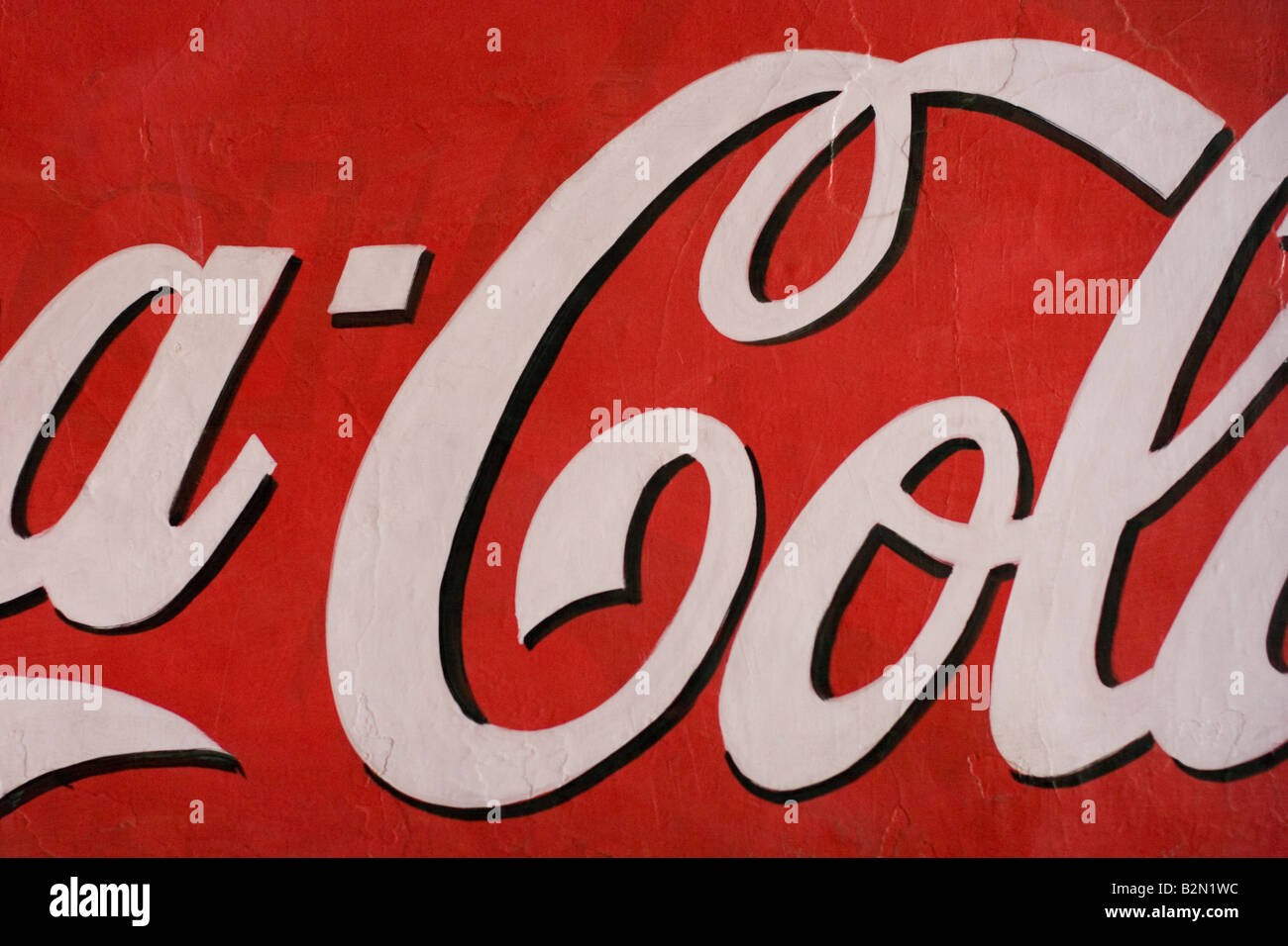 Abschnitt einer hellen Wand gemalt mit einer Coca-Cola-Werbung. Stockfoto