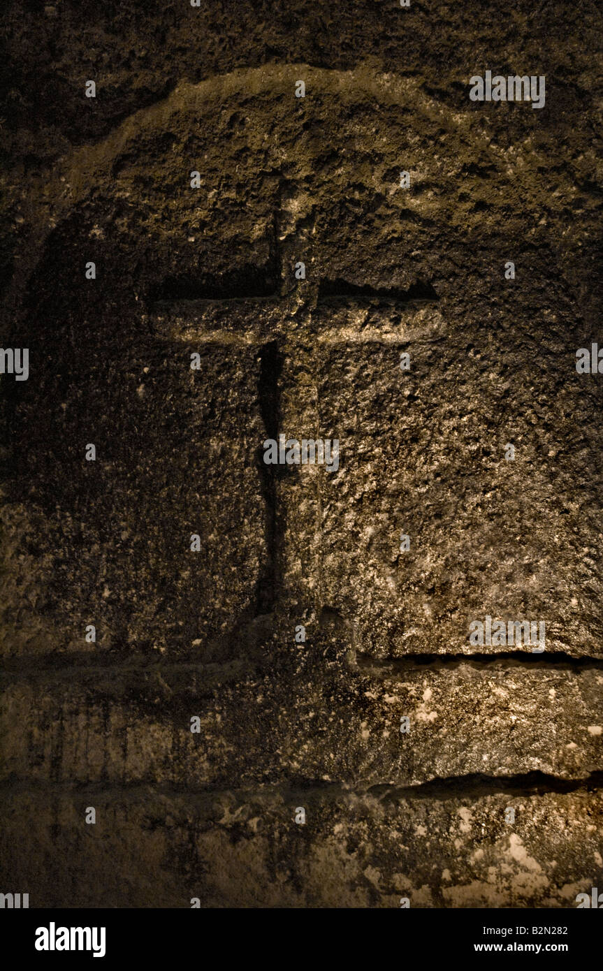 Kreuz in geschnitzt, Steinmauer der Kirche Stockfoto