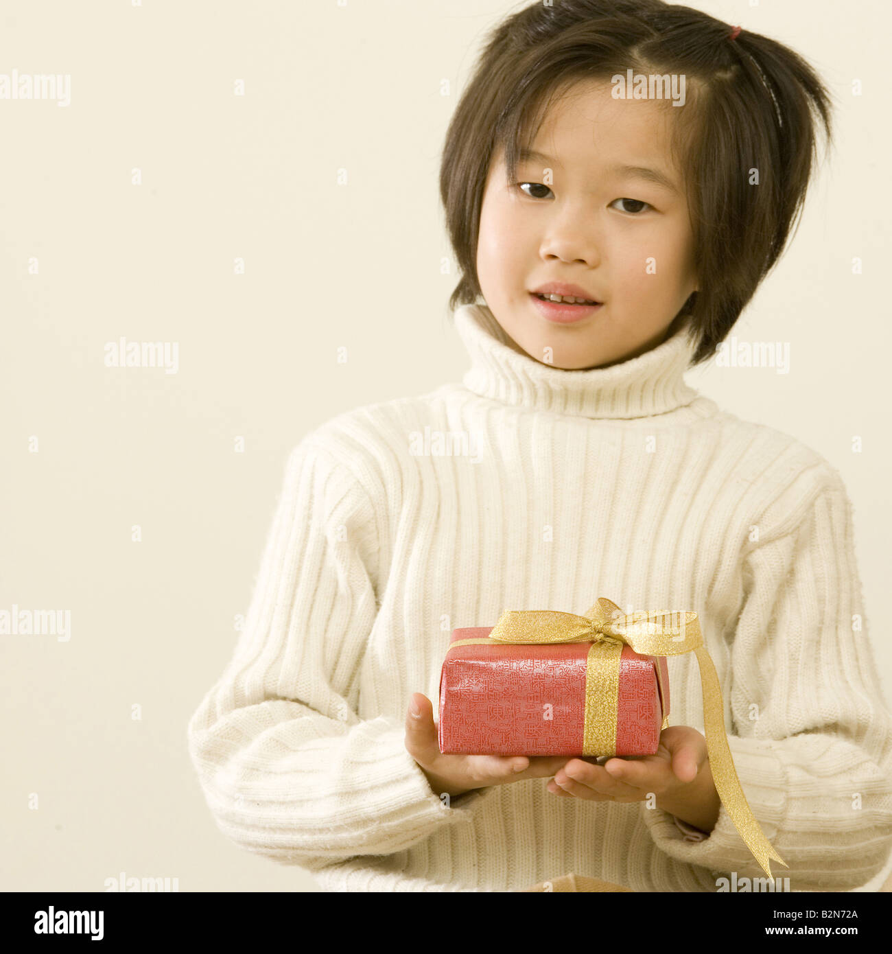 Porträt eines Mädchens hält ein Geschenk und lächelnd Stockfoto