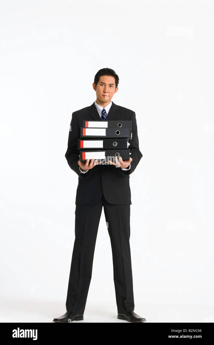 Porträt eines Geschäftsmannes hält einen Stapel von Ringbücher Stockfoto