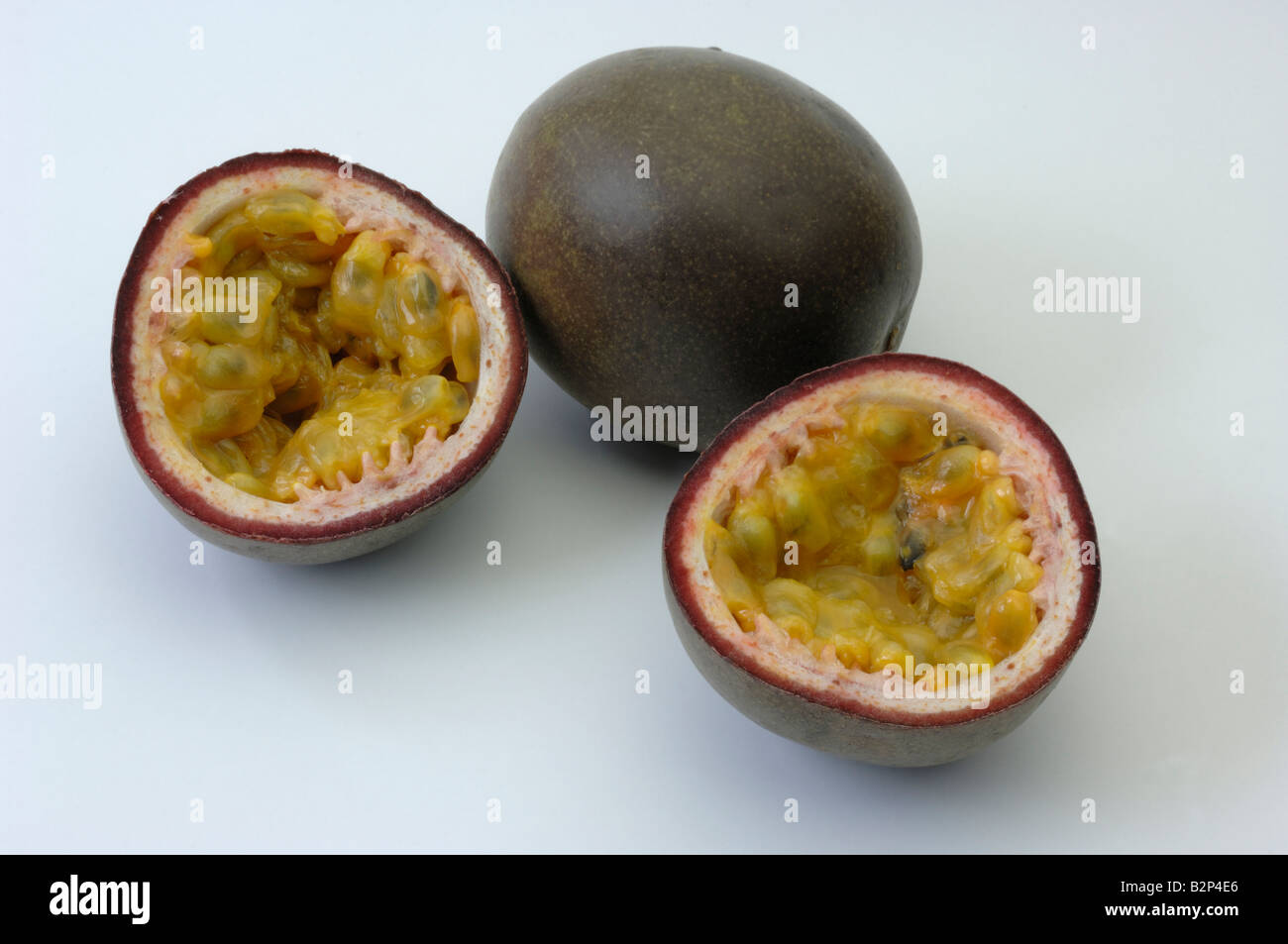 Passionsfrucht (Passiflora Edulis F. Edulis), ganze und halbierte Früchte Studio Bild Stockfoto