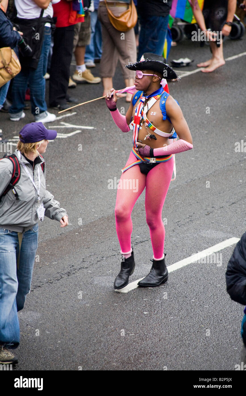 Mann marschieren und tanzen auf der Straße in Brightons Gay Pride Prozession. Menschenmengen säumen die Straßen Stockfoto