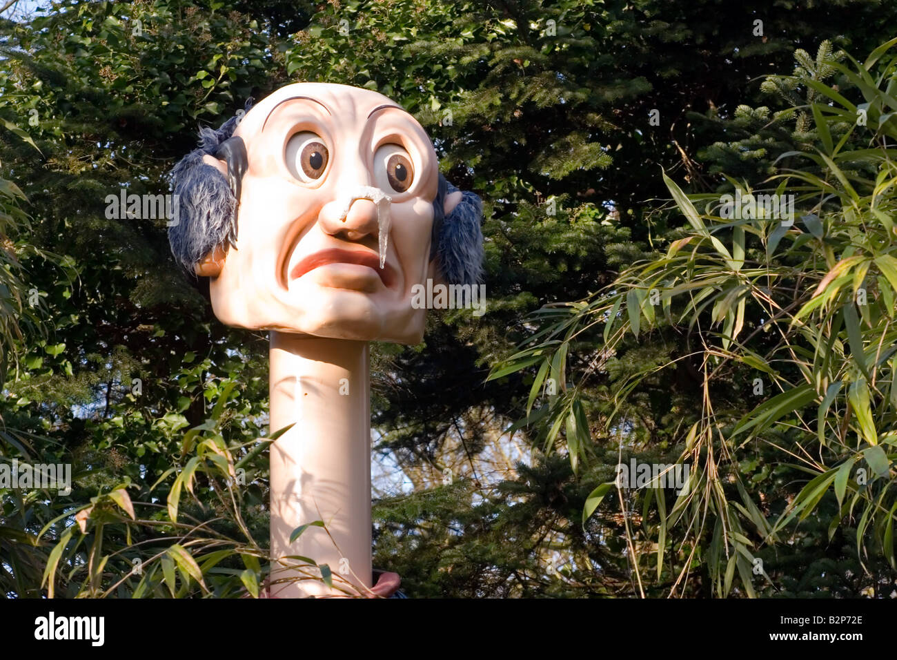 Die Märchen-Figur Langhals (Langnek) hebt seinen Kopf über dem Laub im Freizeitpark Efteling, Kaatsheuvel, Holland Stockfoto