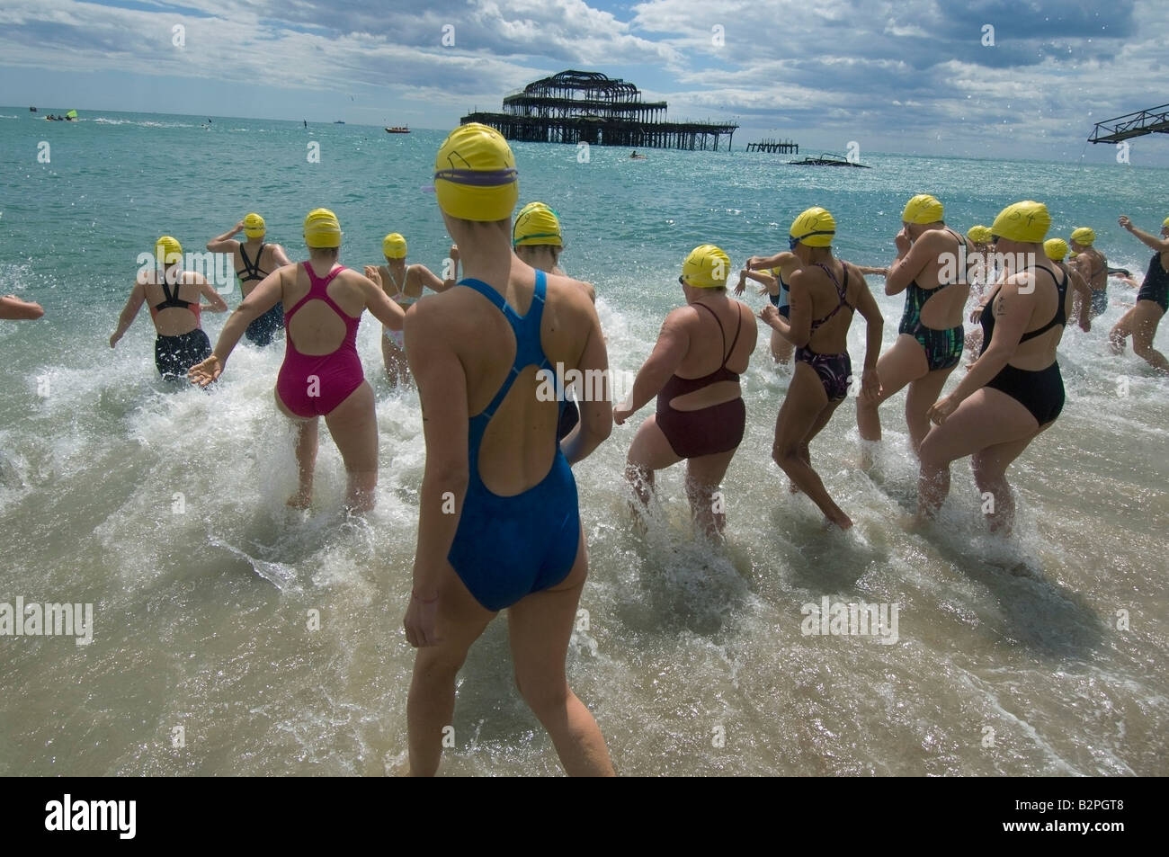Mehr als sechzig Dame Schwimmer schreiten ins Meer durch die Reste der Brightons West Pier bereit für das jährliche Pier, Pier-Rennen Stockfoto