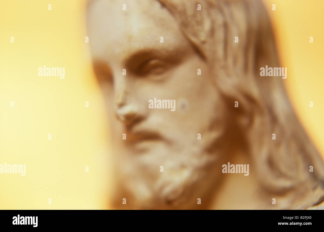Klangschöne Nahaufnahme von Marmorkopf Jesu Christi mit abgebrochenen Nase und Schimmel vor Ort mit warmen sonnigen Hintergrund Stockfoto