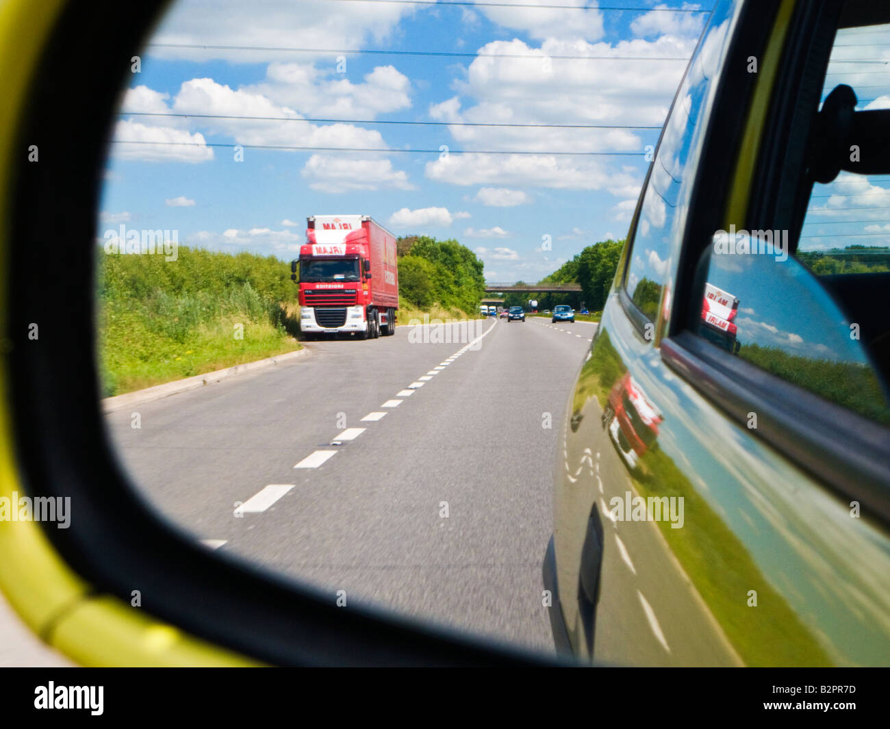 Blick auf der Straße hinter - Rückansicht einer englischen zweispurigen Straße durch eine Auto-Außenspiegel UK Stockfoto