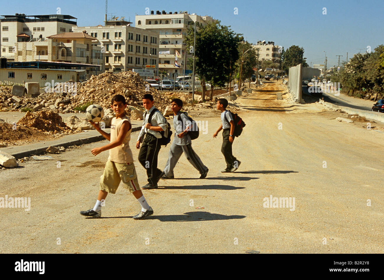 Schüler mit Fußball zu Fuß in der Nähe von Israelischen West Bank Barrier, Jerusalem, Israel, Naher Osten Stockfoto