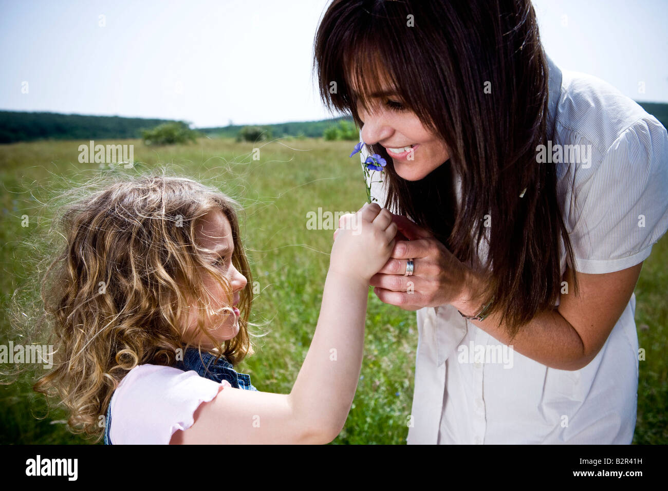 Frau duftenden Blume mit Tochter Stockfoto