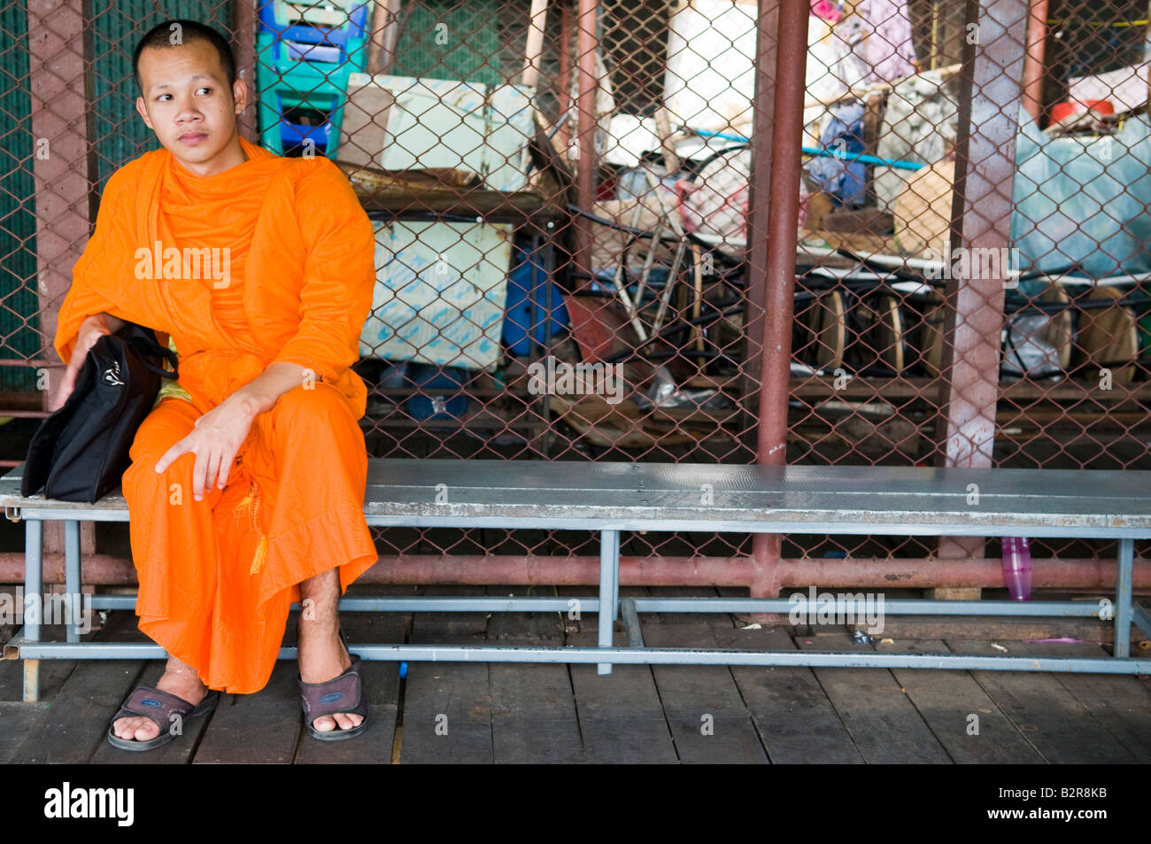 Ein buddhistischer Mönch sitzen auf einer Bank in Bangkok, Thailand Stockfoto