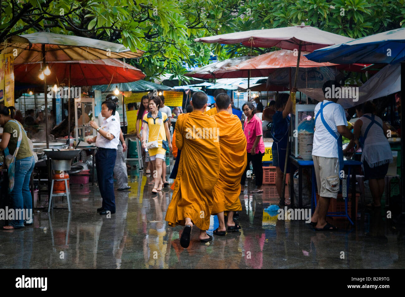 buddhistische Mönche gehen durch einen thailändischen Markt Stockfoto