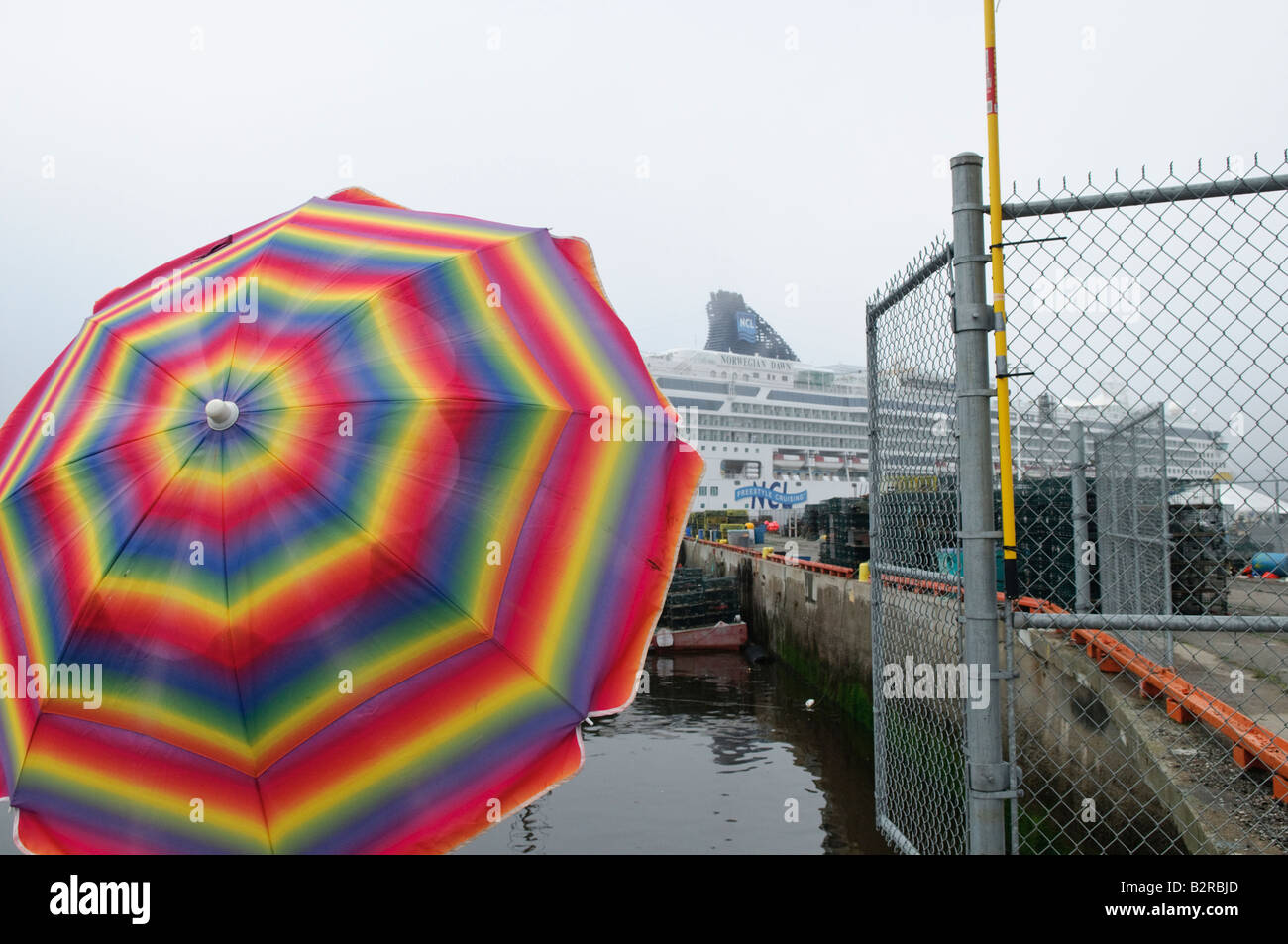 Norwegische Kreuzfahrt Schiff norwegian Dawn am Dock in Saint John mit Regenbogen farbige Regenschirm im Vordergrund Stockfoto