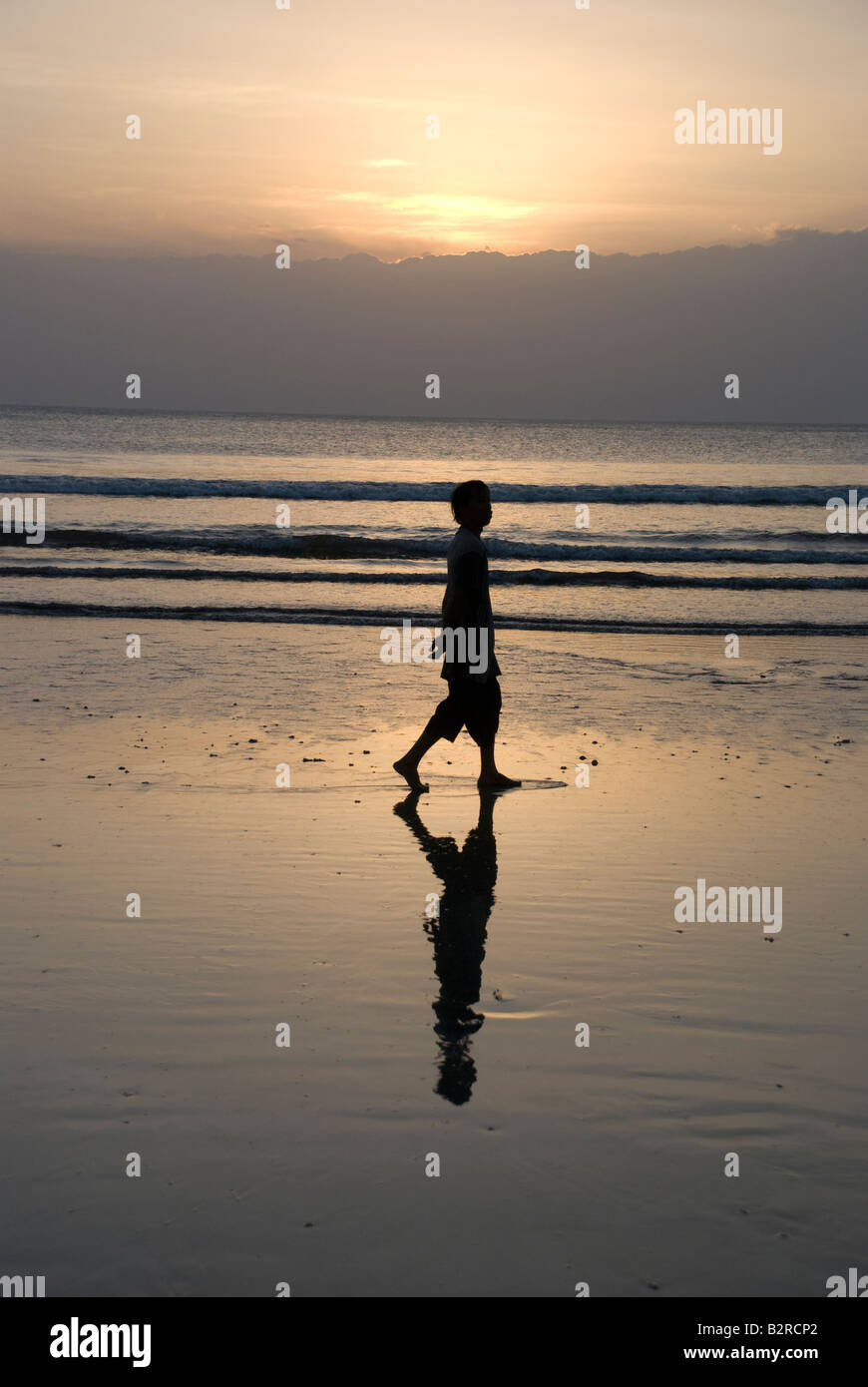 Kuta Bali Indonesien Badebucht Meer Surf Sonnenuntergang Mann Frau zu Fuß Kontemplation Wolke Himmel Wellen kräuseln Reflexion Silhouette Stockfoto