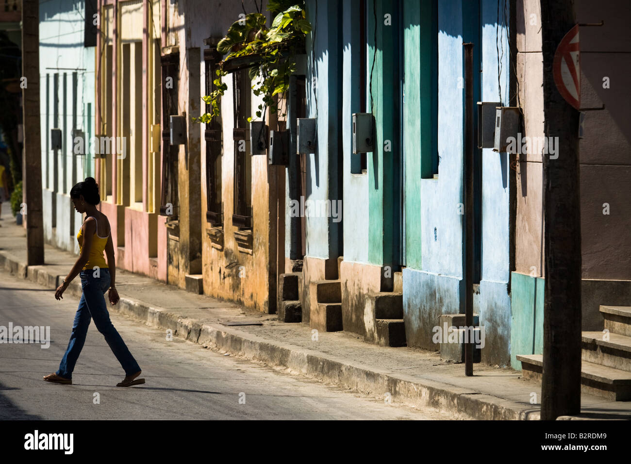 Eine Frau kommt auf der anderen Straßenseite in Baracoa, Kuba Stockfoto