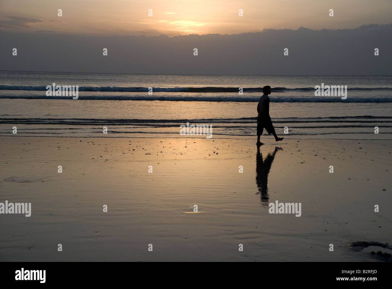 Kuta Bali Indonesien Badebucht Meer Surf Sonnenuntergang Mann Frau zu Fuß Kontemplation Wolke Himmel Wellen kräuseln Reflexion Silhouette Stockfoto