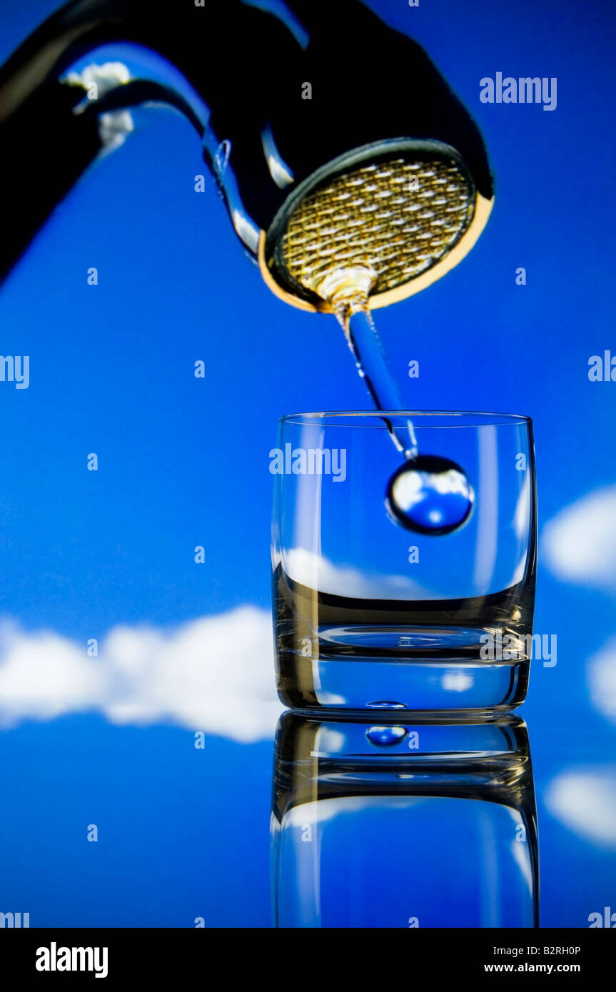 Konzept Erhaltung Fragen große Tröpfchen von Wasser aus großen Hahn fallen in ein kleines Glas Stockfoto