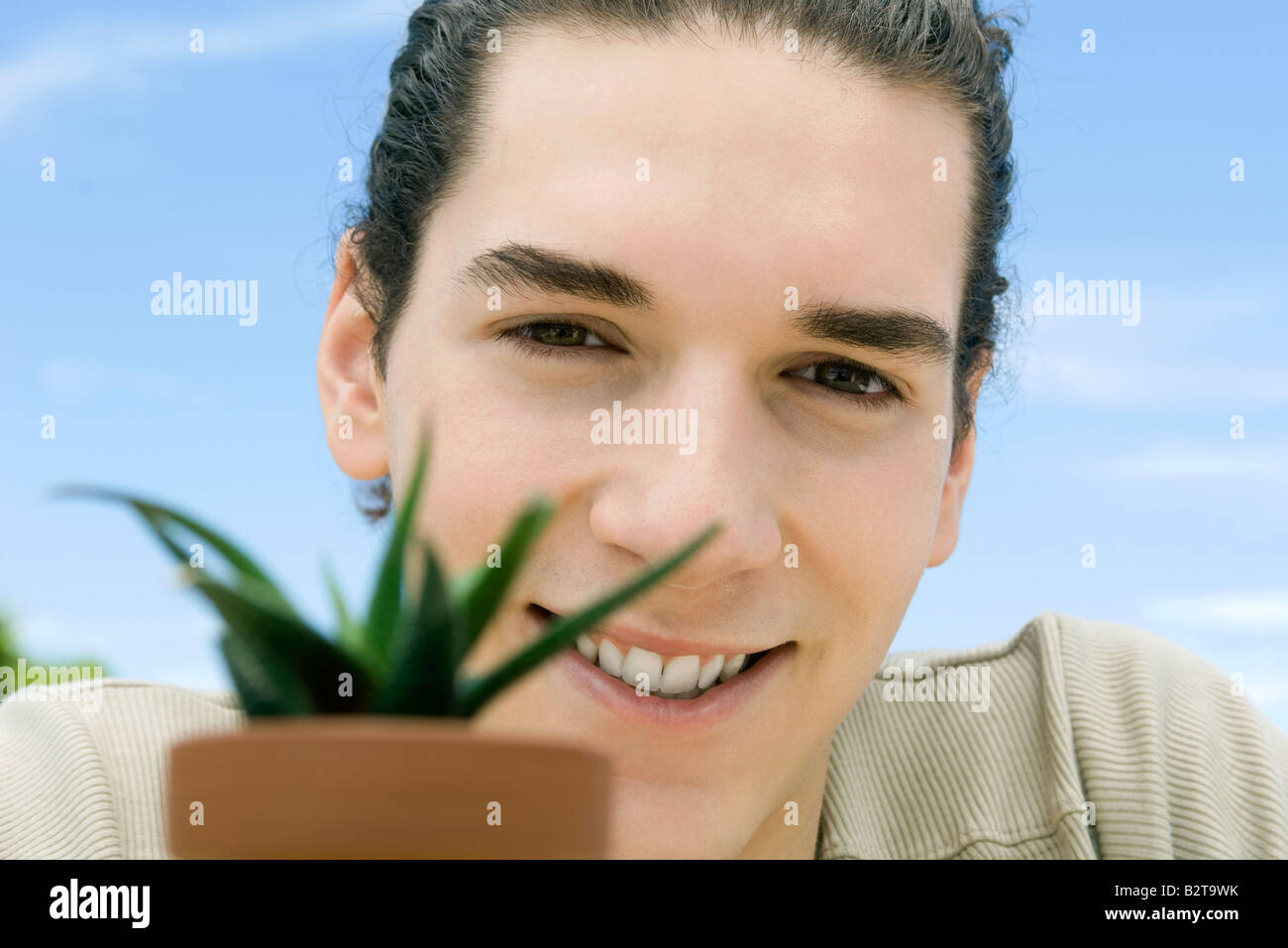 Junger Mann mit Pflanze Stockfoto