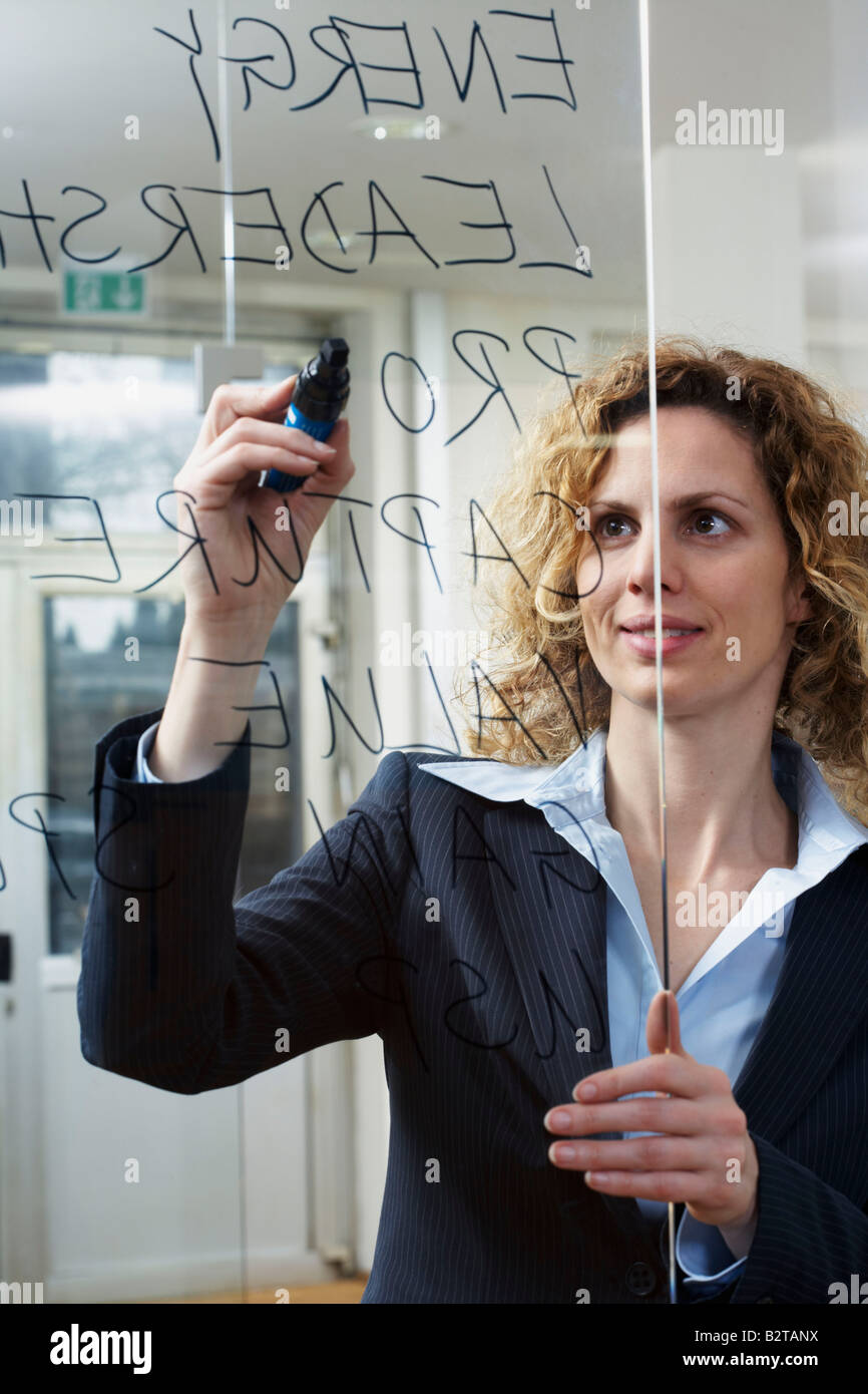 Geschäftsfrau schreiben Schlüsselwörter auf Glas Stockfoto