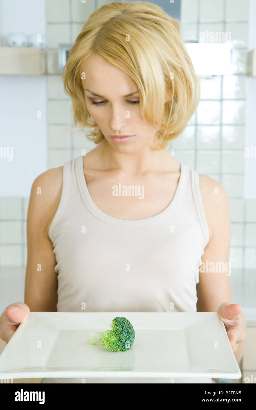 Frau Halteplatte mit einem Stück von Brokkoli, Blick nach unten Stockfoto