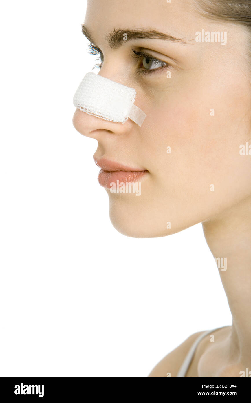 Junge Frau mit verbundenem Nase, Profil, beschnitten Stockfoto
