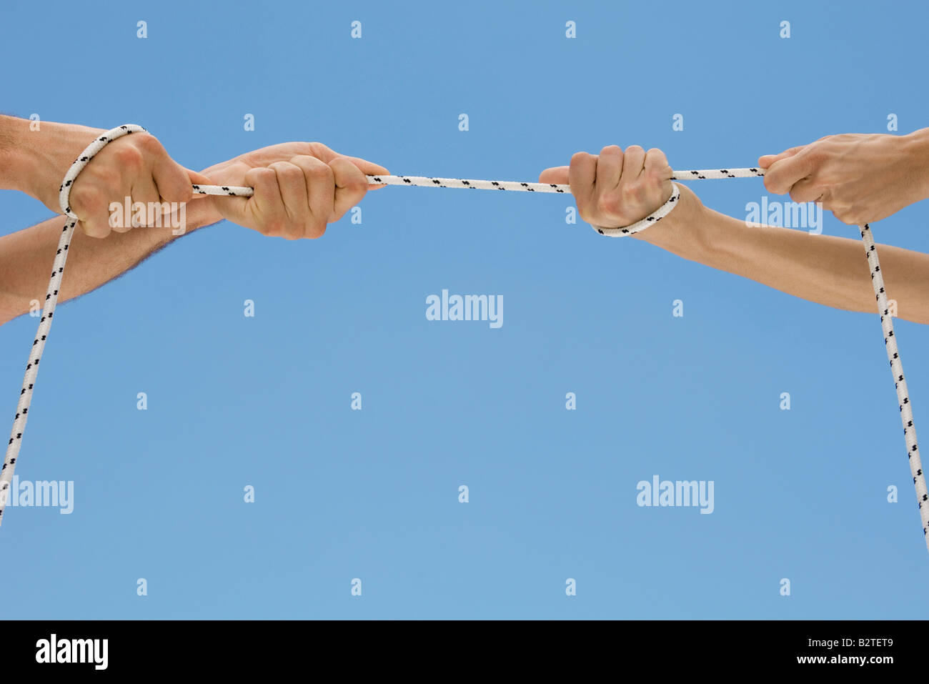 Hände spielen Tauziehen mit Seil Stockfoto