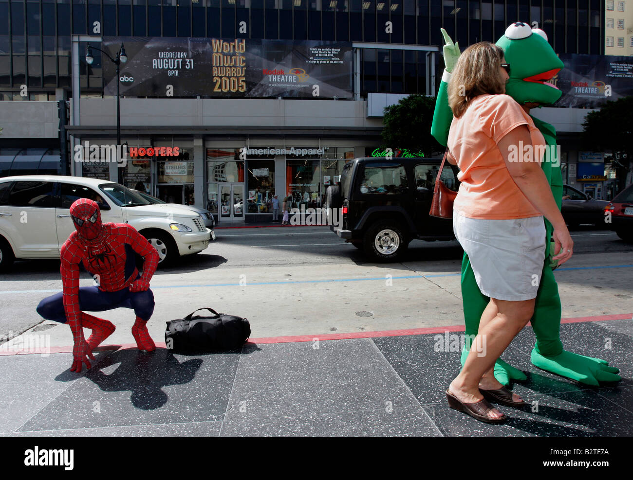 USA LOS ANGELES A Tourist posiert mit Kermit des Frosches am Hollywood Boulevard Spiderman ist Foto GERRIT DE HEUS beobachten. Stockfoto