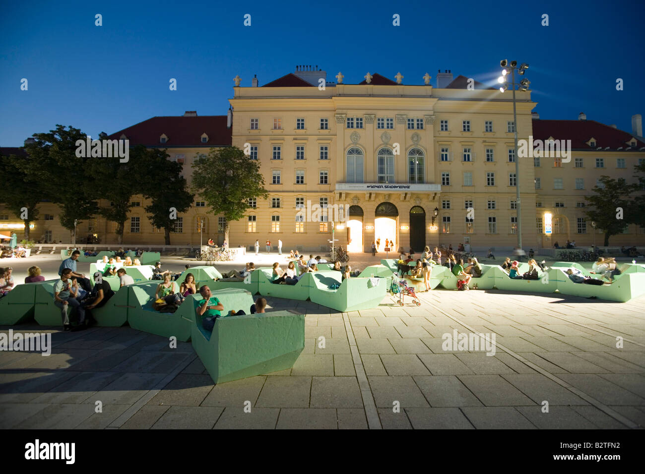 Leute sitzen in Sitzgelegenheiten vor den ehemaligen kaiserlichen Hofstallungen im MuseumsQuartier, Wien, Österreich Stockfoto