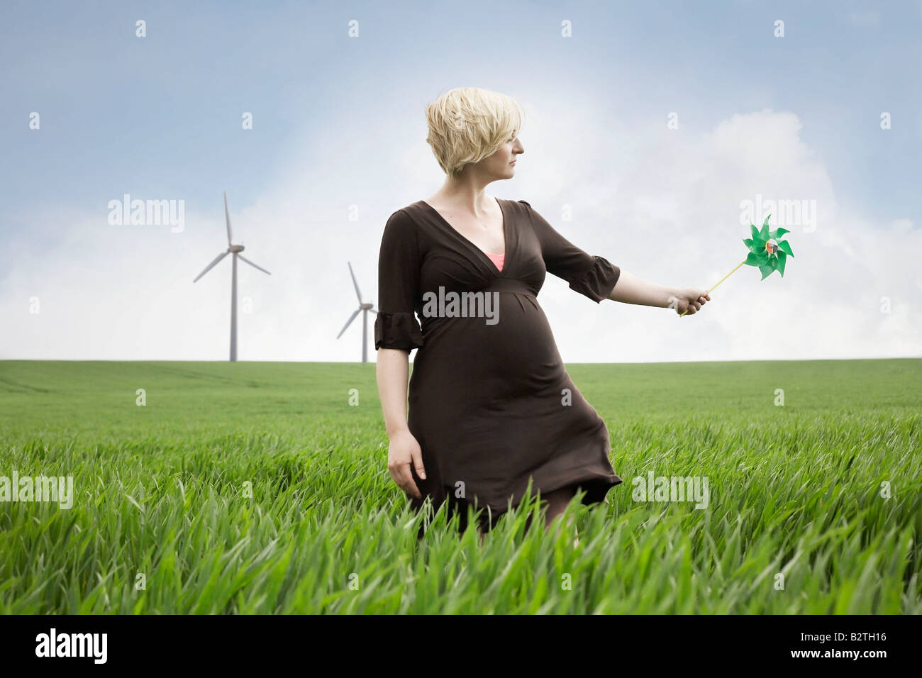 Schwangere Frau spielt mit Windmühle Stockfoto