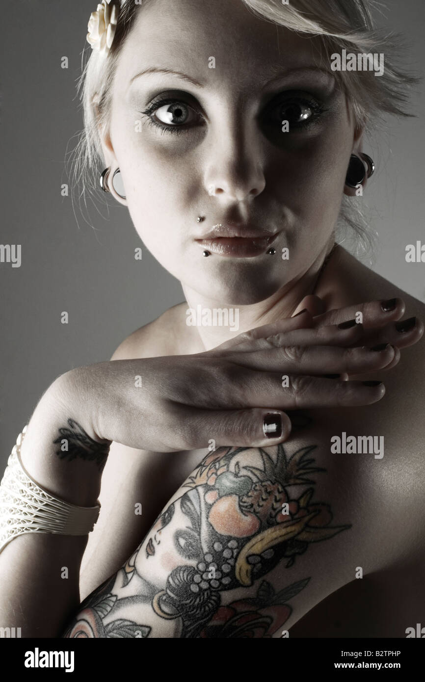 Kopf und Schultern Porträt einer blonden GothFrau mit Piercings und