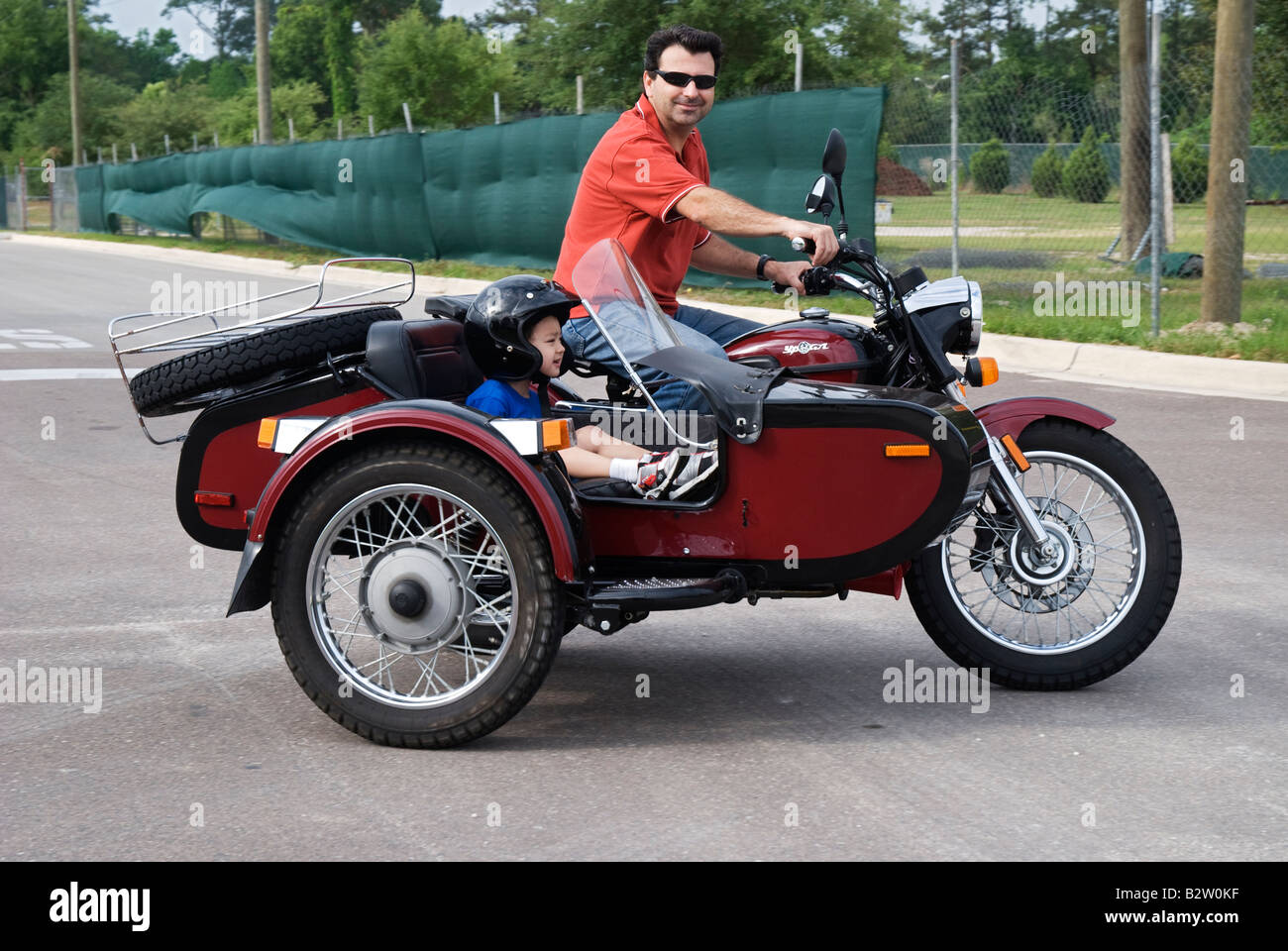Mann auf dem Motorrad mit Kind im Beiwagen Gainesville Florida URAL YPAN Motorrad aus Russland Stockfoto
