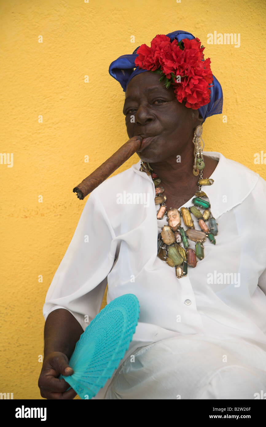 Kubanische Frau trägt ein Santeria weißen Kleid, einer großen Zigarre in Havanna Vieja Havanna in Kuba. Stockfoto