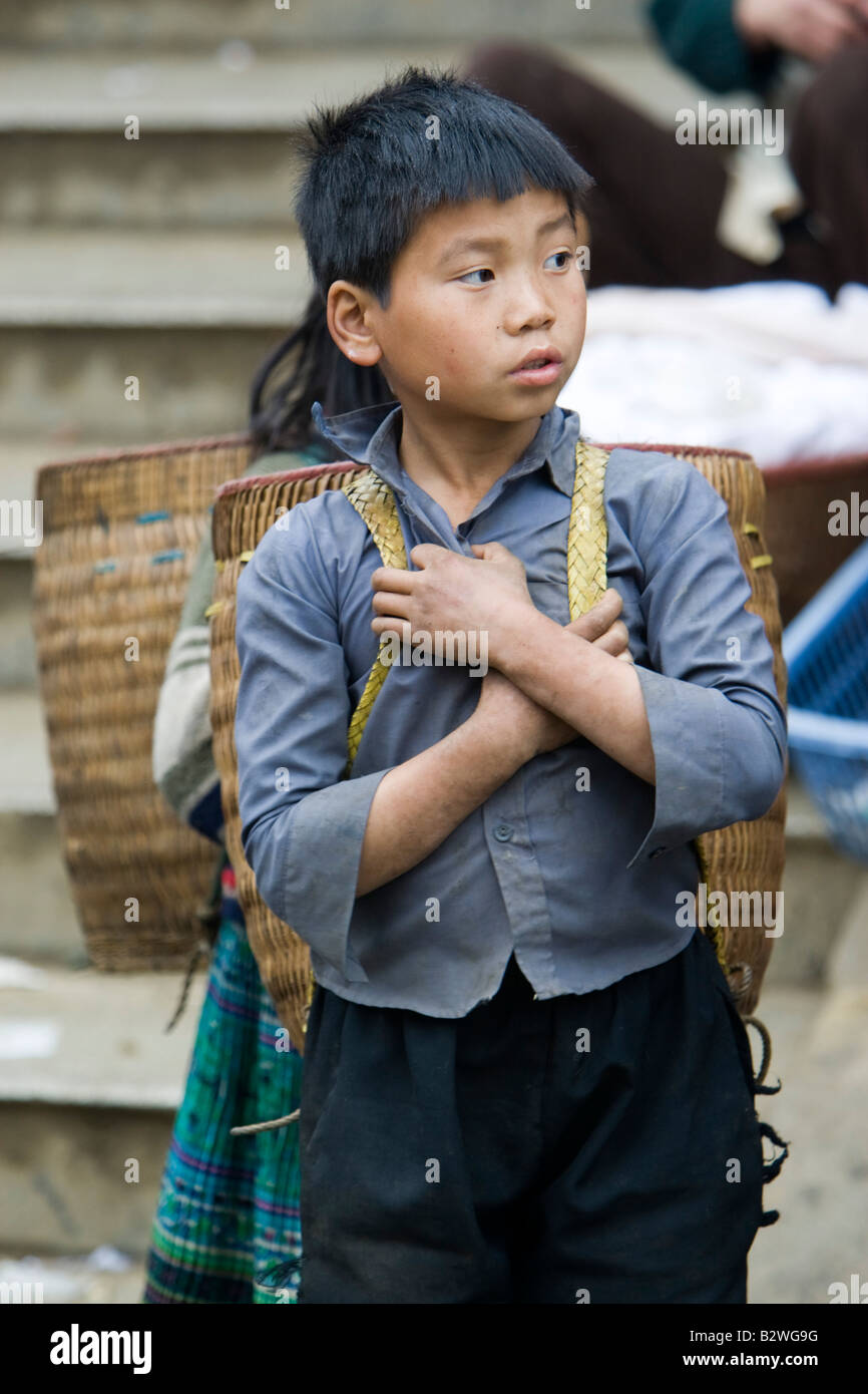 Black Hmong Hilltribe junge mit traditionellen Schulter Korb wartet am Markt Sapa Vietnam Stockfoto
