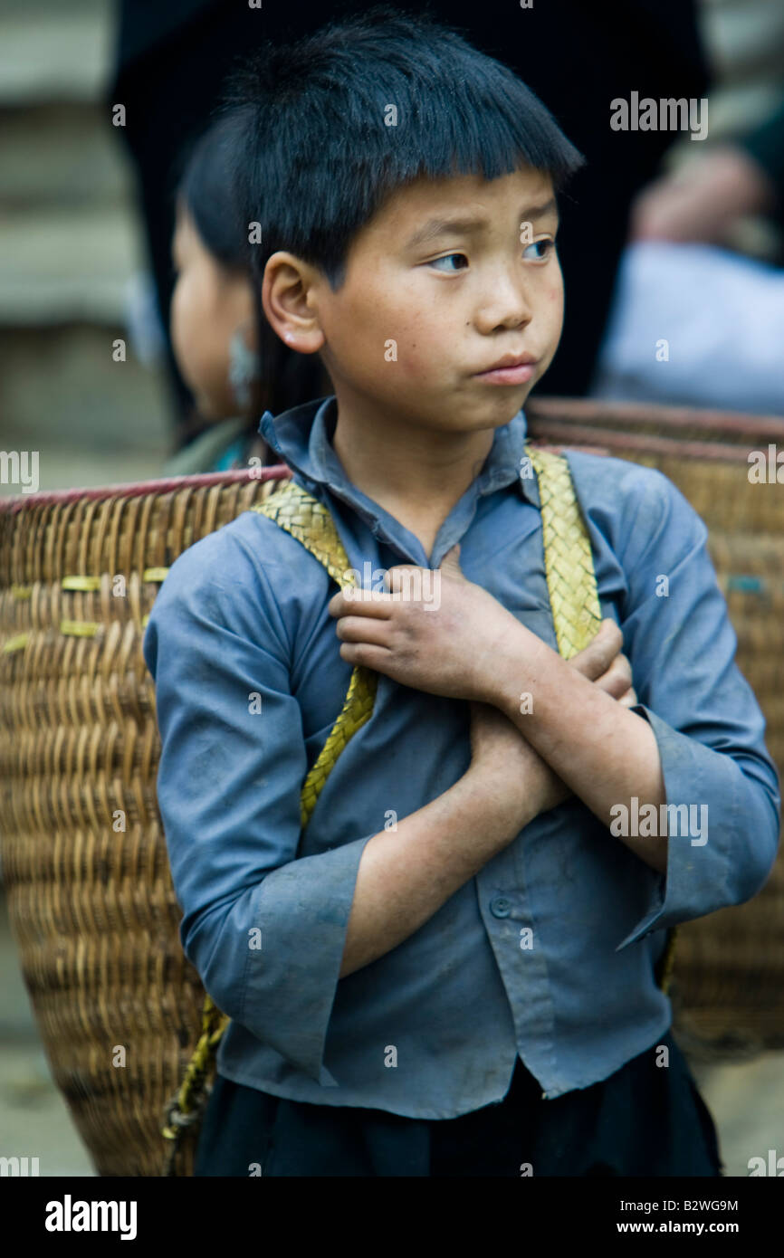 Black Hmong Hilltribe junge mit traditionellen Schulter Korb wartet am Markt Sapa Vietnam Stockfoto