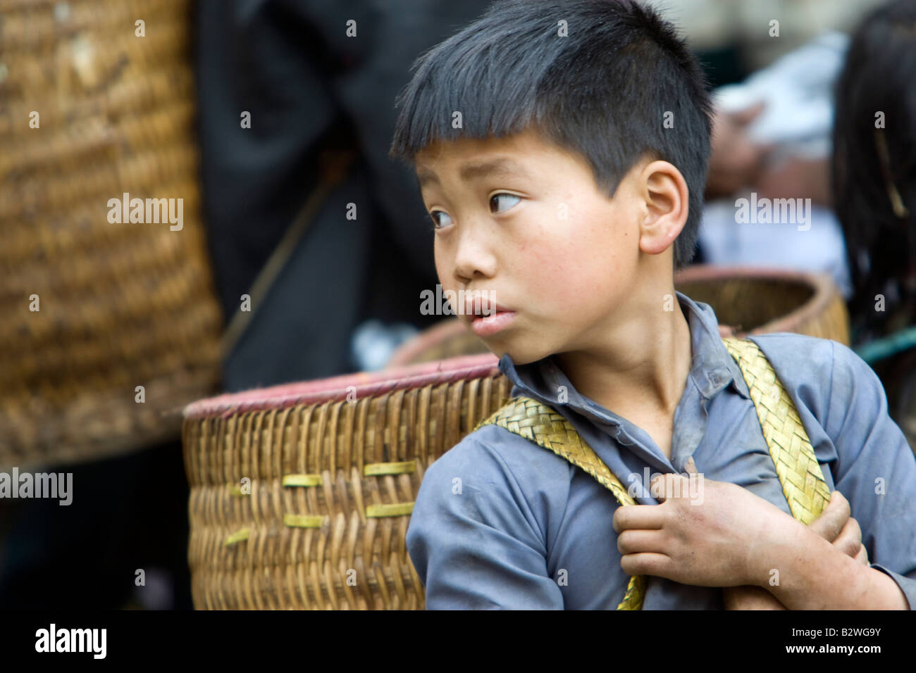Black Hmong Hilltribe junge mit traditionellen Schulter Korb wartet am Markt Sapa Vietnam Stockfoto