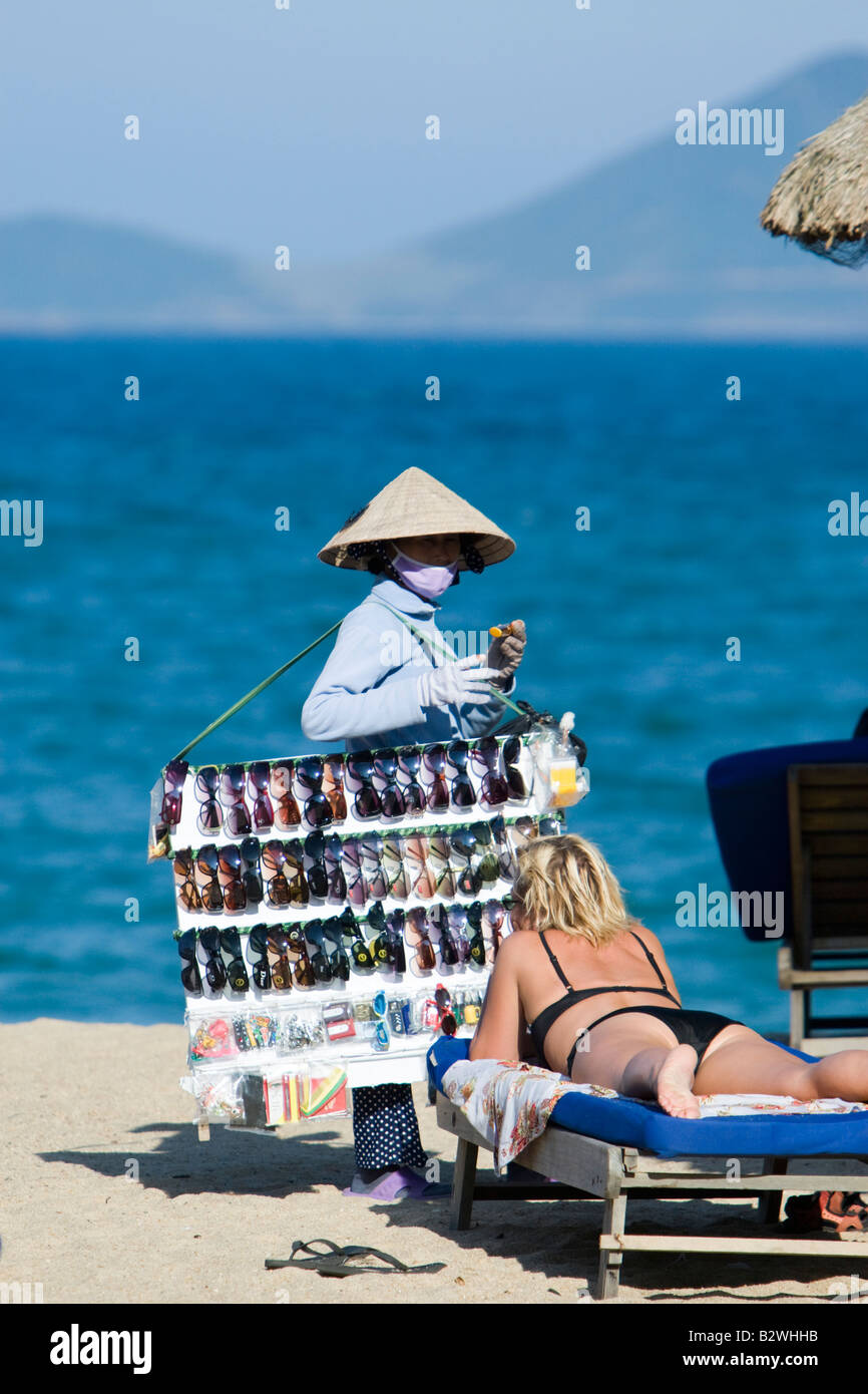 Konische Hut Frau verkaufen Sonnenbrille am Strand von Nha Trang Resort Vietnam Stockfoto