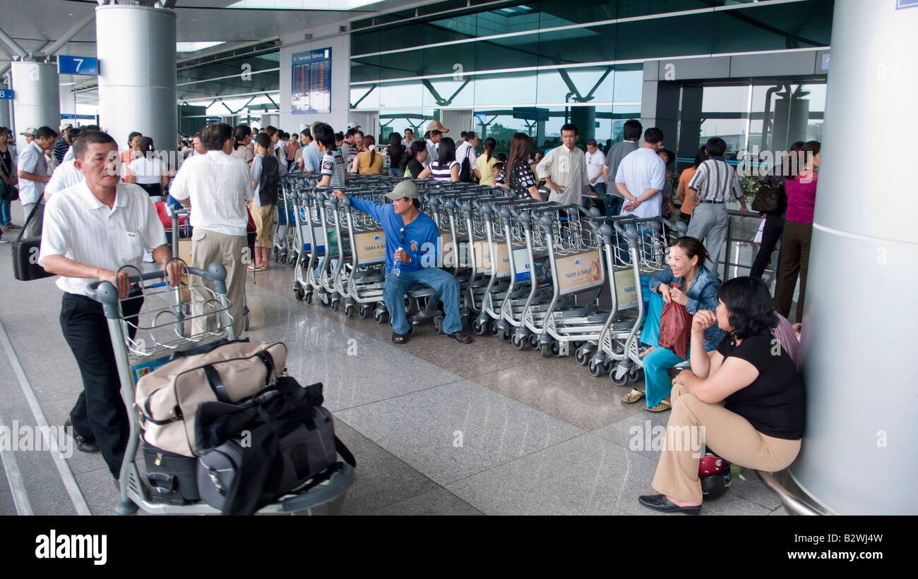 Gepäckwagen und Passagiere außerhalb Flughafen Tan Son Nhat in Ho Chi Minh City Vietnam Stockfoto