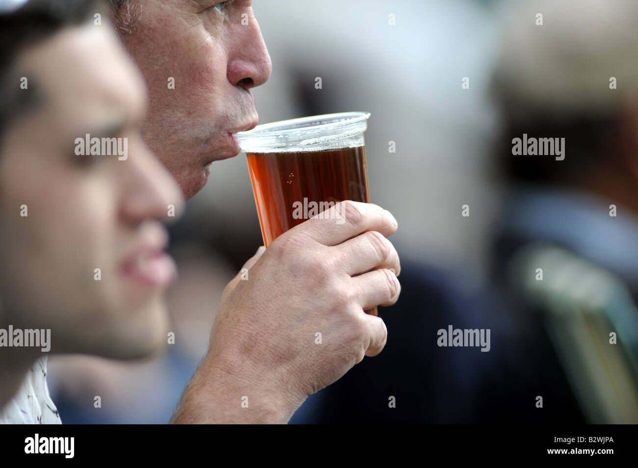 Mann nippt ein Pint Bier, während er Cricket auf dem malerischen Arundel Ground beobachtet Stockfoto