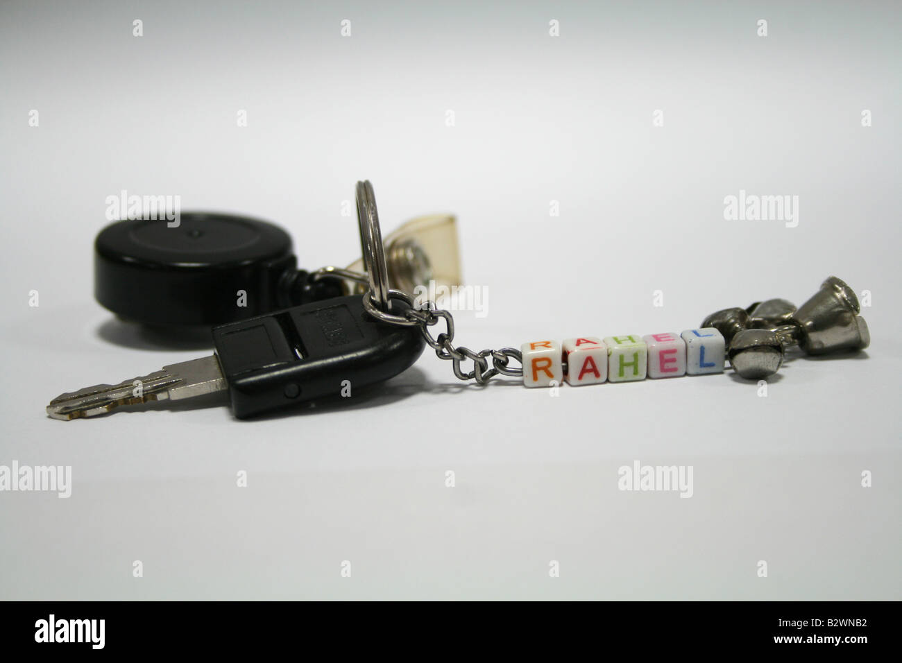 Schicke schwarze Schlüsselanhänger mit Personalausweis Riemen und Gürtel-Clip an Silberkette bunten Buchstaben mit silbernen Glocken am Ende befestigt Stockfoto