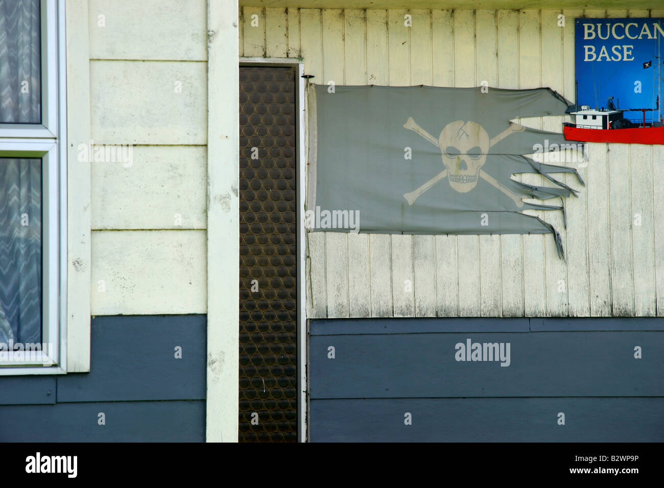 Eine Piratenflagge auf ein Haus in dem abgelegenen Fischerdorf Weiler Jackson Bay an der Westküste der Südinsel, Neuseeland Stockfoto